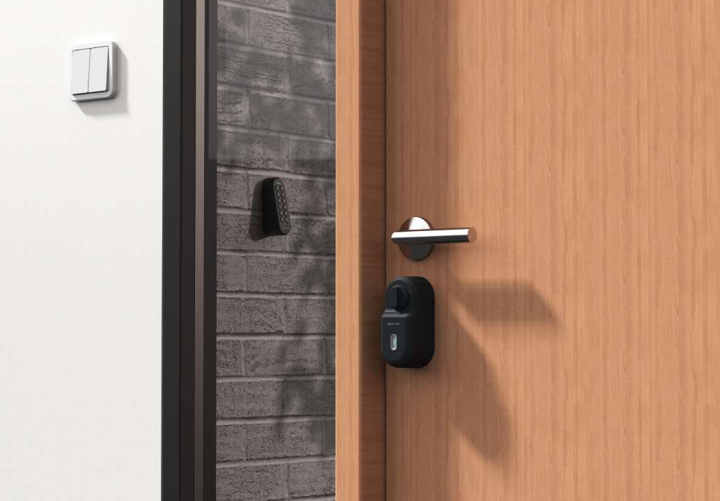 Une porte en bois avec une poignée moderne argentée et une serrure intelligente noire est légèrement ouverte - smart homes airbnb