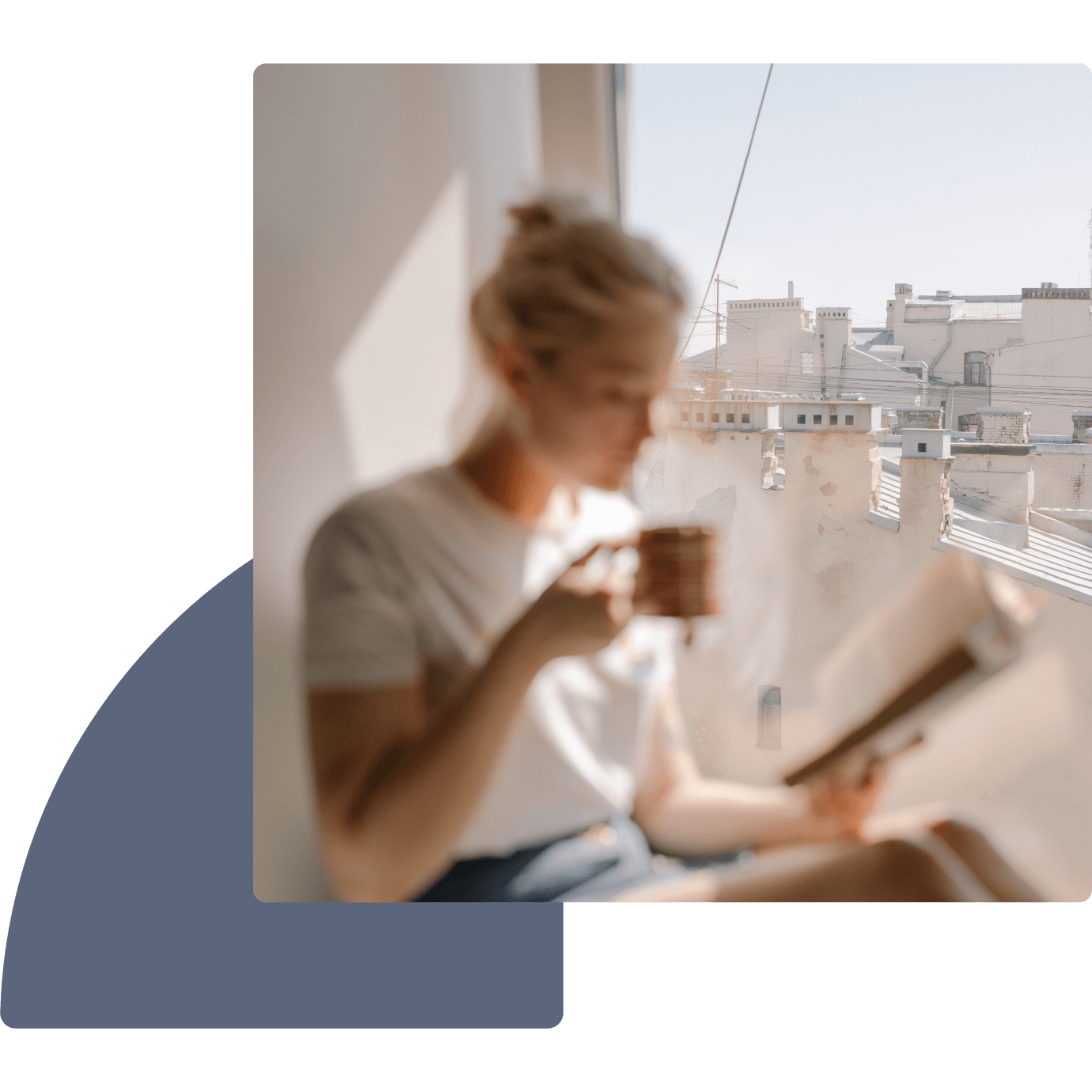 a woman sitting on a window sill reading a book and holding a cup