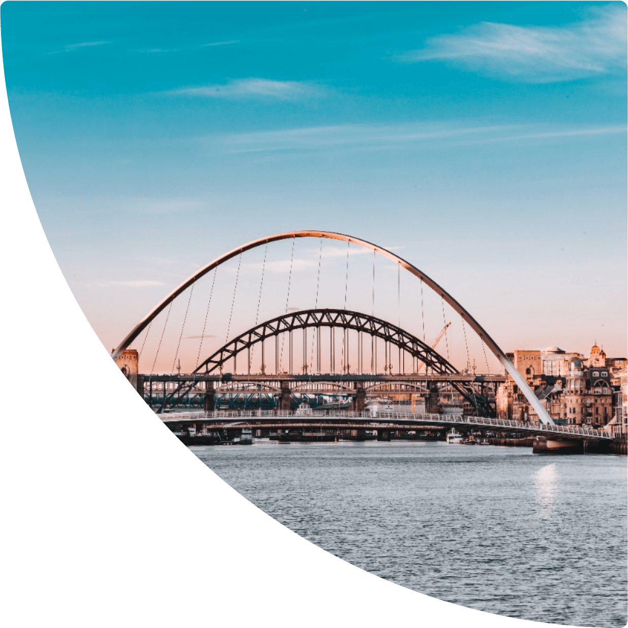 a bridge over water with buildings in the background