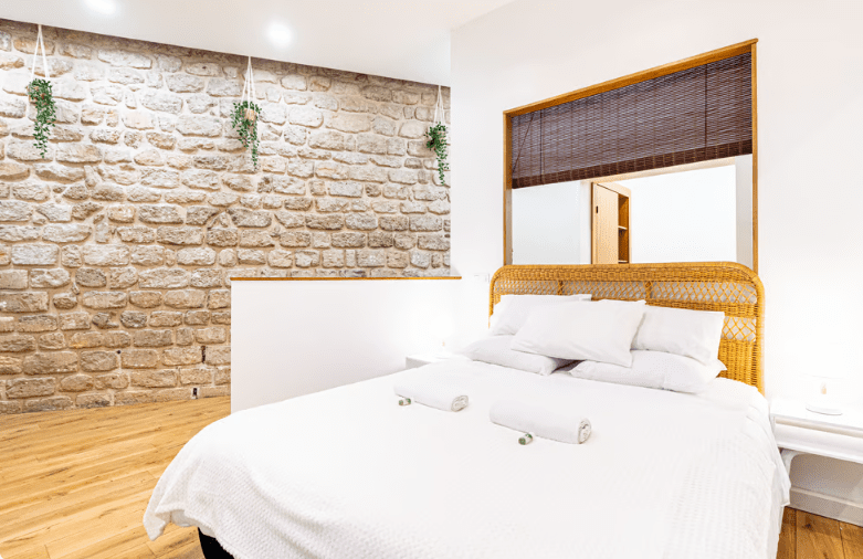 a bed with white sheets and towels on it