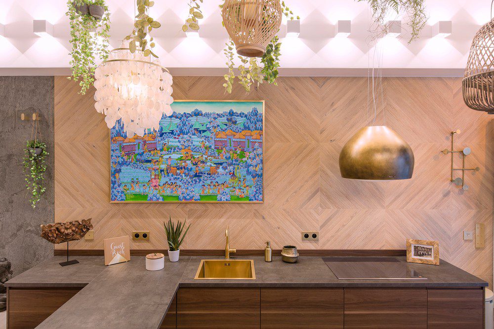 Stylish modern kitchen in a furnished apartment, designed for short term rental with high end finishes, decorative lighting, and functional workspace.