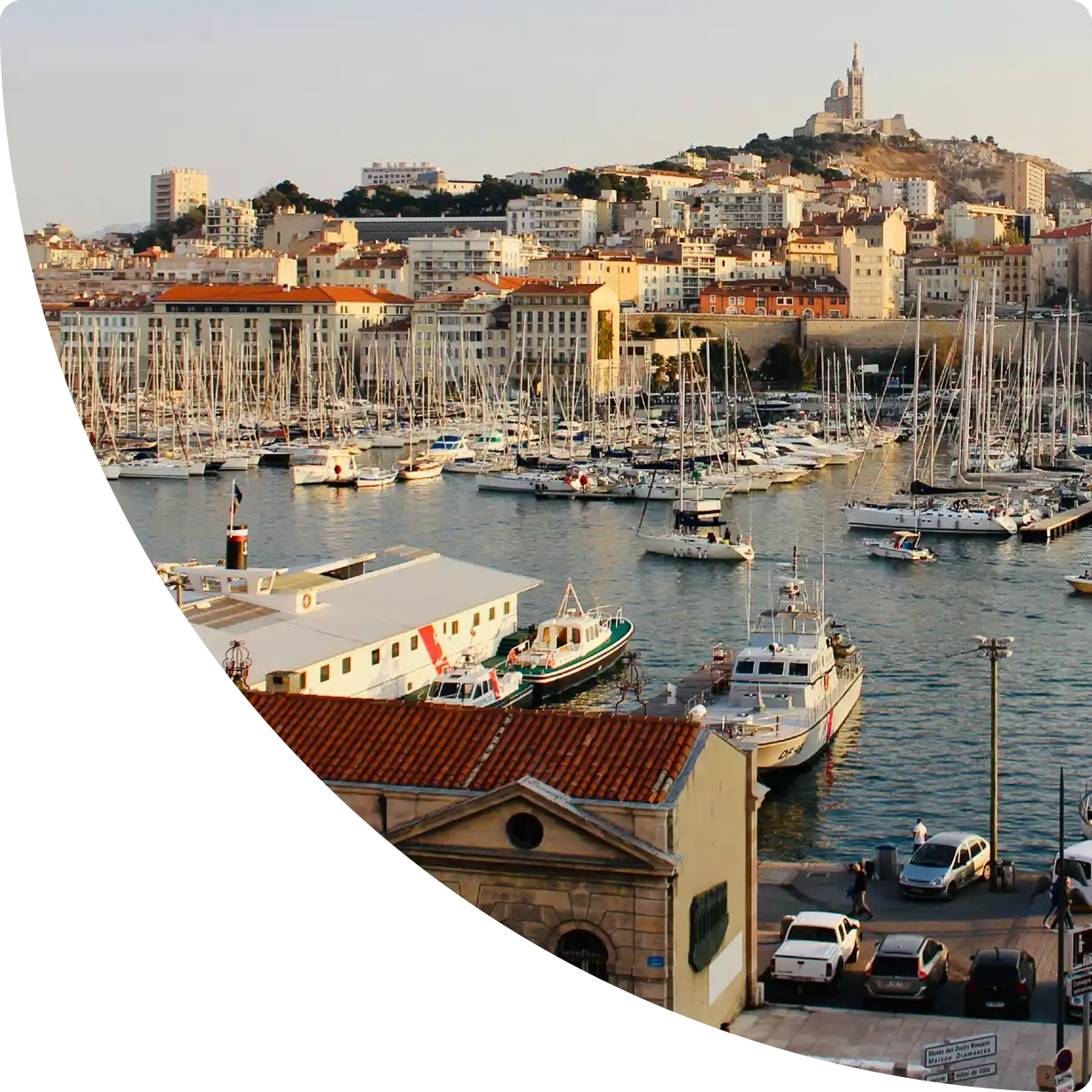 Marseille Old Port with boats, hillside cityscape, and Notre-Dame de la Garde — Airbnb management in Marseille