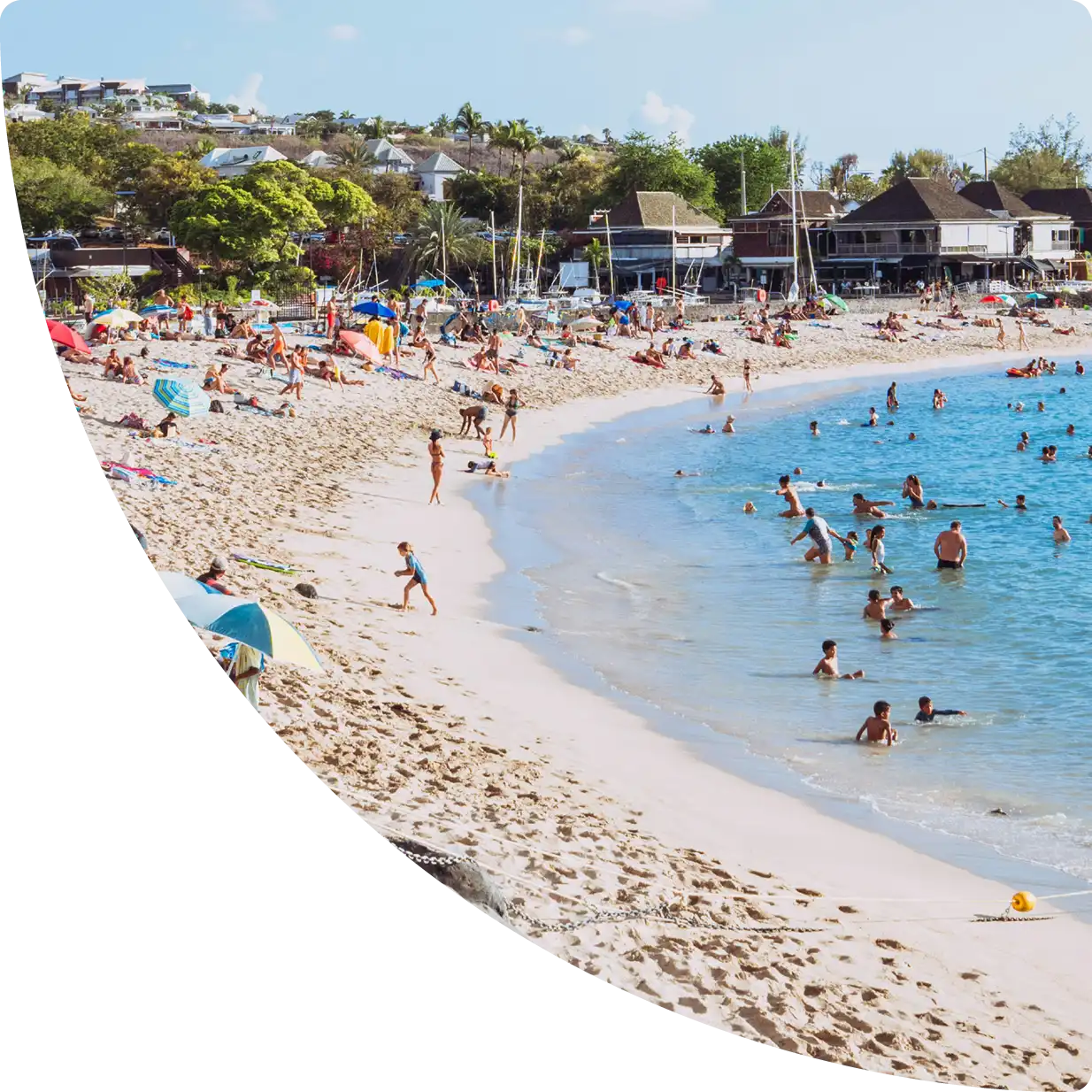 Lively beach in La Réunion with swimmers, white sand, and turquoise water — Airbnb management in Réunion