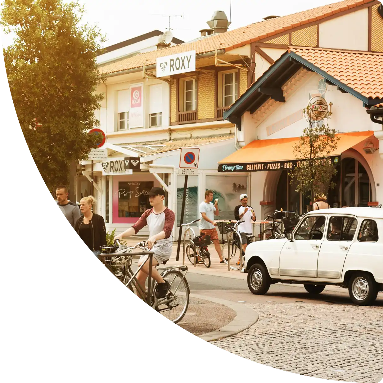 Centre-ville animé dans les Landes avec commerces, cyclistes et rues ensoleillées — conciergerie Airbnb