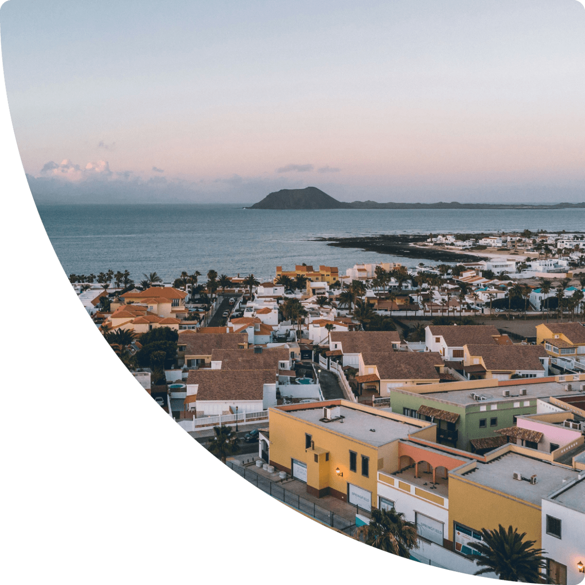 Panoramic view of a coastal village with the ocean at sunset