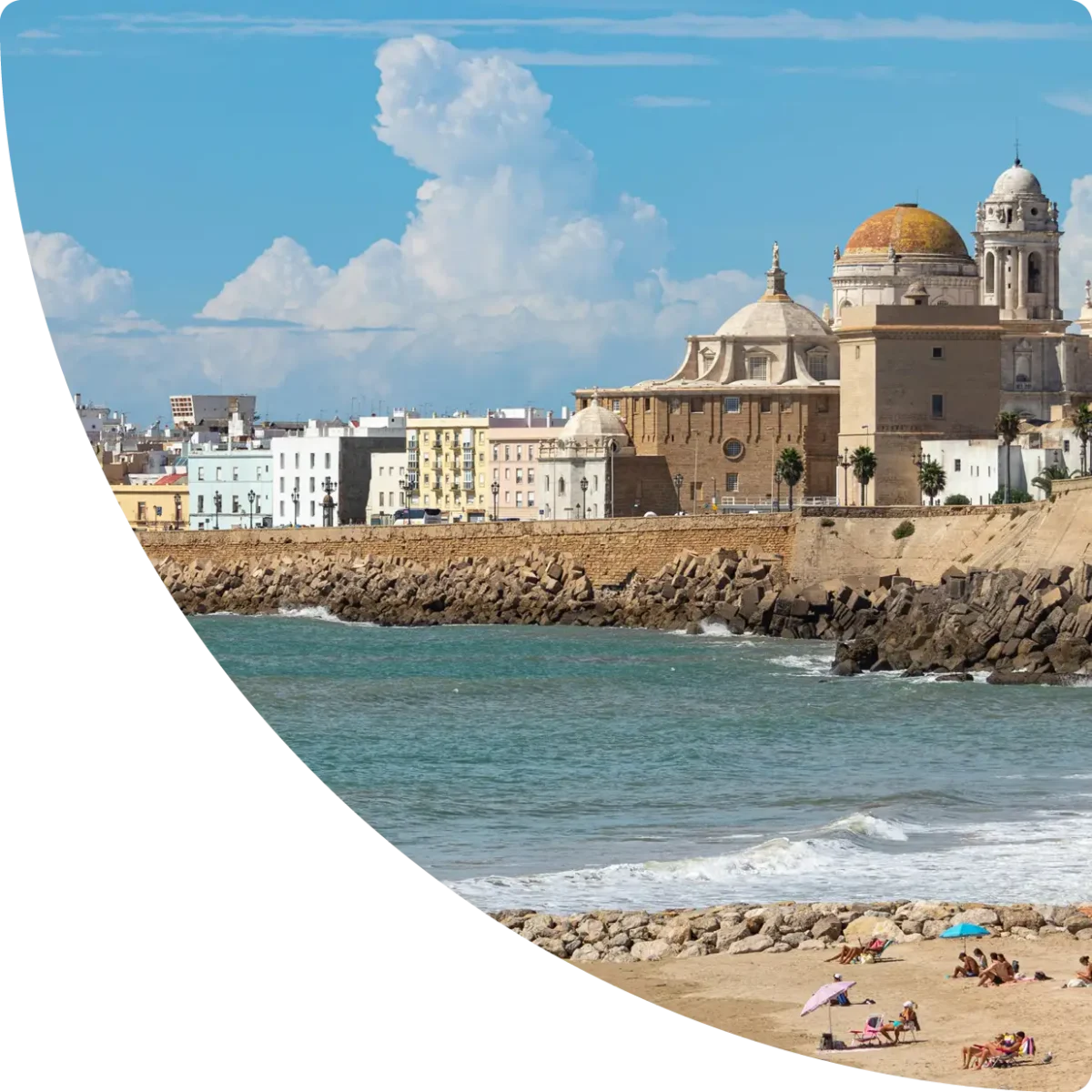 Cádiz seafront with the cathedral’s golden dome overlooking the water on a sunny day - Airbnb management in Cádiz, GuestReady