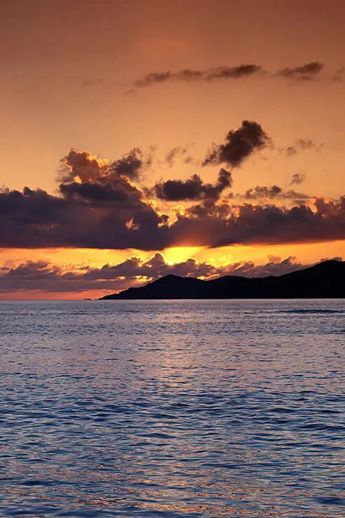 Coucher de soleil sur l’océan avec nuages spectaculaires et silhouette d’île — conciergerie Airbnb La réunion