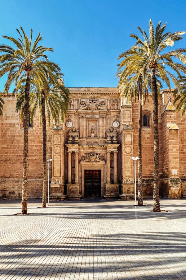 Catedral histórica con palmeras en el centro de la ciudad bajo cielo azul, gestión alquiler turístico en Almería