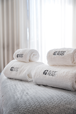 Serviettes blanches soigneusement pliées sur un lit dans un logement moderne - Fin Airbnb Paris?