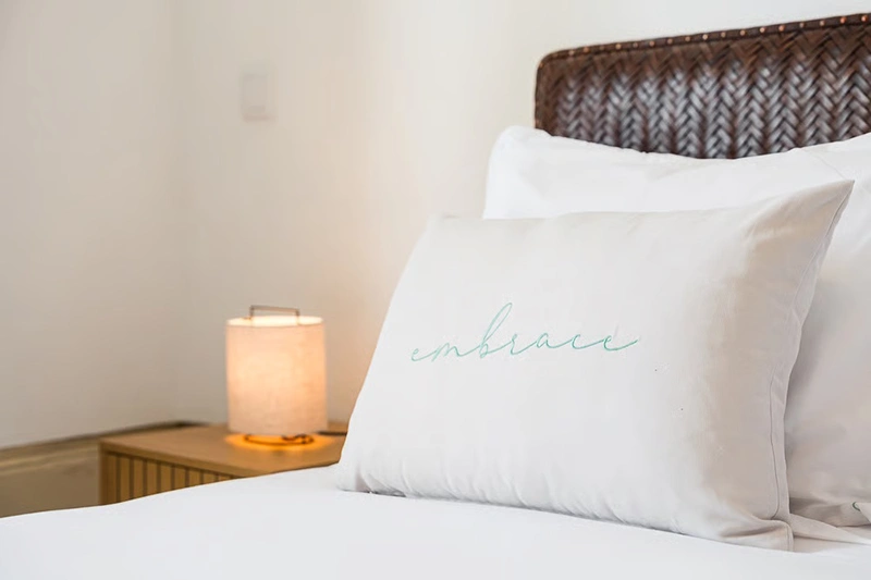 Lit confortable avec coussins blancs et lampe de chevet, meilleures conciergerie airbnb à Lyon